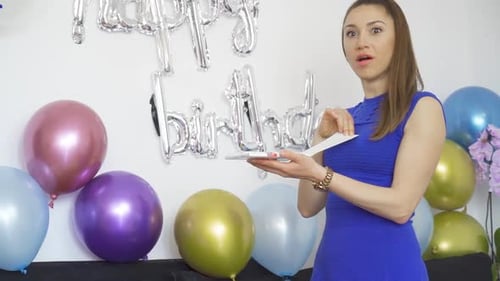 Woman Celebrates Birthday with Balloons and Card