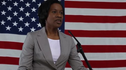 Woman Speaking at Podium in Front of US Flag