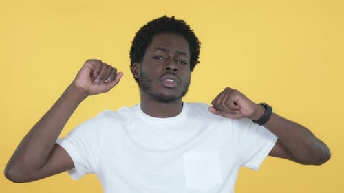 Young Man Dancing Energetically on Yellow Background