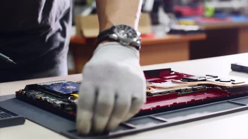 Técnico profesional separa el disco duro portátil SSD reparándolo en el taller