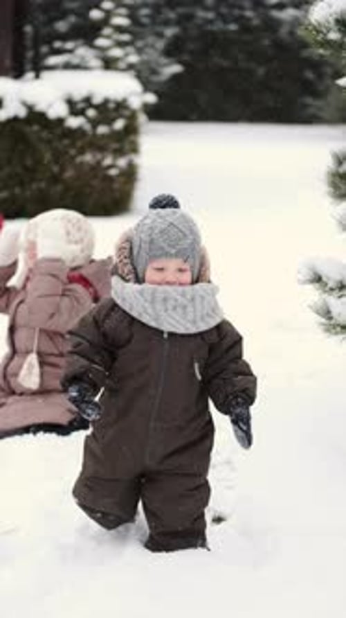 Kinder beim Bau eines Schneemanns an einem Wintertag im Hinterhof