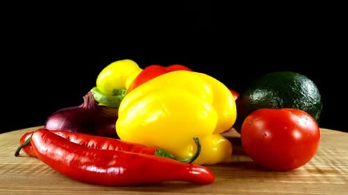 Fresh vegetables rotate on a wooden surface