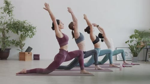 Women Doing Yoga in Bright Studio