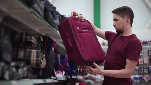 Man is Examining Suitcase in Trade Area of Store