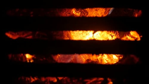 Burned fire behind the steel grate close-up 4K 2160p 30fps UltraHD footage - Flame spreading arrou