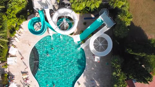Fliegen Sie über einen großen Pool mit blauem Wasser und vielen Touristen bei heißem Wetter