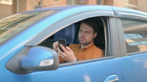 Young Adult Using Smartphone in Car