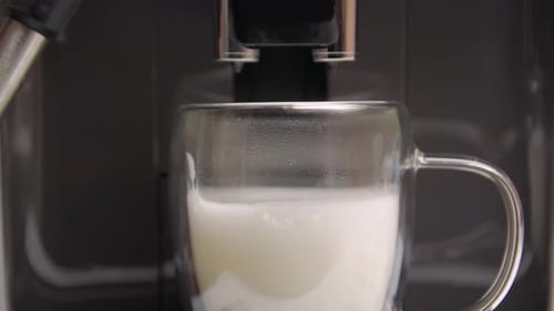 Espresso Machine Dispenses Foamy Milk into Glass Mug