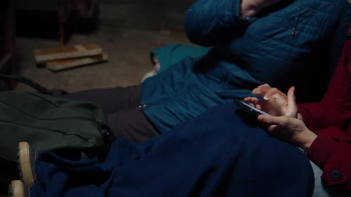 Duas mulheres usando um telefone quando se escondem em um abrigo