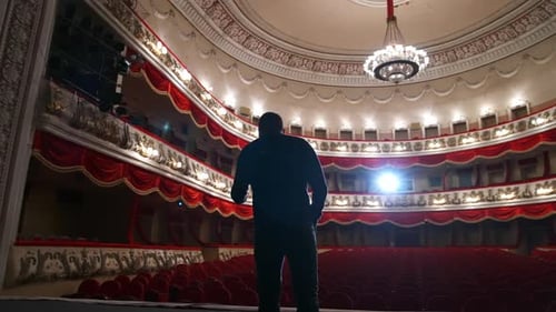 Successful Motivational Speaker. Empty classic theater. No people in hall because of pandemic.