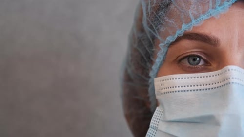 Healthcare Worker Adjusts Her Mask