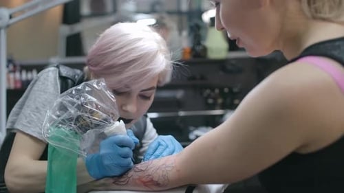 Woman Getting Floral Tattoo in Tattoo Parlor