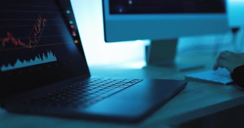 Laptop Displaying Stock Market Data With Person Typing