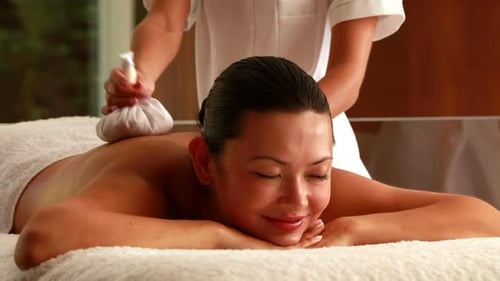 Gorgeous woman getting a massage with herbal compresses
