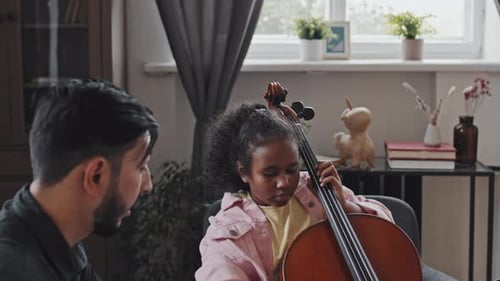 Girl Learns to Play Cello with Instructor