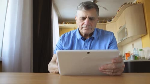 Man Using Tablet Device in Home Setting