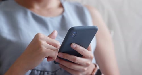 Woman use of cellphone and sit on sofa at home