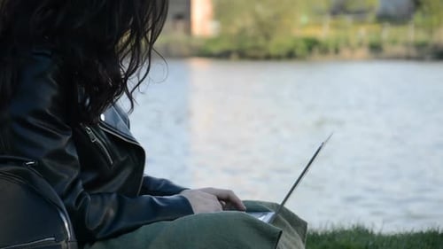 Woman Uses Laptop in Outdoors Near Water