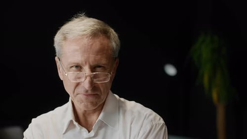 Portrait Of Successful Mature Businessman Looking At Camera In Office