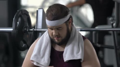 Sweaty Man Drinking Water at Gym
