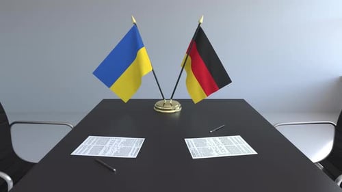 Ukraine and Germany Flags on Conference Table with Documents