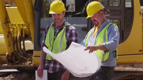 Construction Workers Reviewing Blueprints on Construction Site
