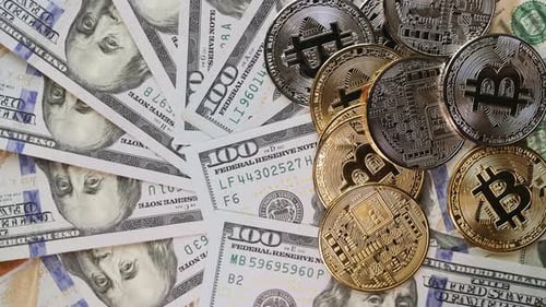 BTC. Bitcoin cryptocurrency. Gold and silver coins rotating on dollars banknotes