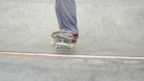 Skater Practicing in the Autumn Concrete Skate Park Making Tricks and Rides in Ramp