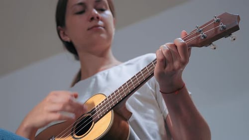 Girl Playing Ukulele in White Studio