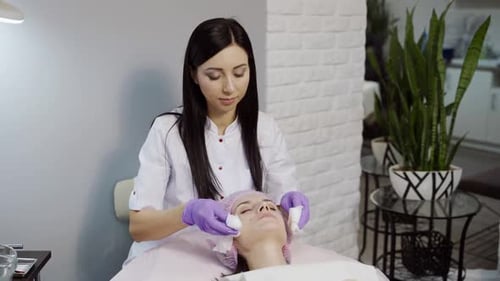 Skin care concept. Beautician is making a facial rejuvenation procedure for woman