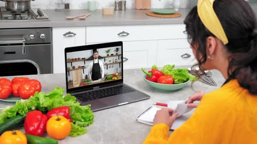 Woman Takes Notes During Online Cooking Class