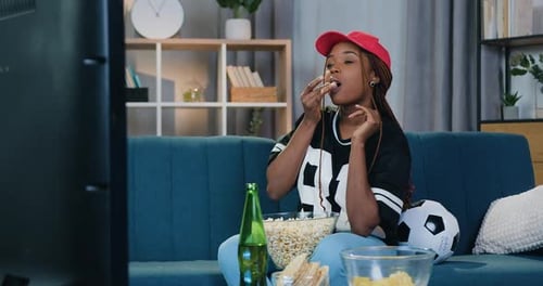 Woman Enjoys TV, Snacks, and Beer at Home