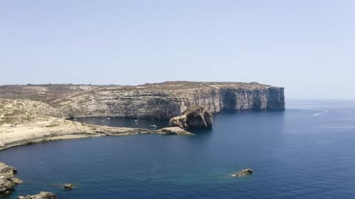 Dwerja sea bay with anchored yachts between massive rock cliffs,Malta.