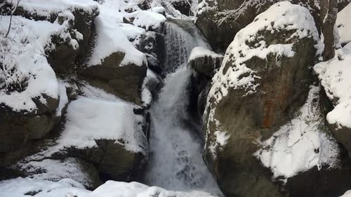 Snowy Waterfall Cascading Over Rocks in Winter