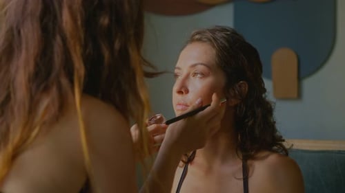Woman Applying Makeup to Friend Indoors