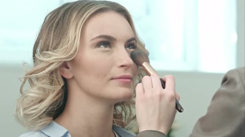 Woman Having Makeup Applied With Brush in Studio