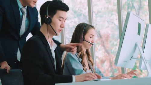 Geschäftsleute mit Headset, die im Büro arbeiten