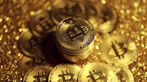 Gold Bitcoin Coins Close Up on Glittery Surface