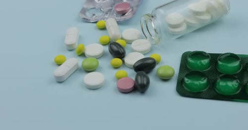 Assorted Colorful Pills and Tablets on Blue Surface