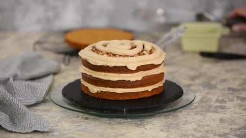 Girl Making a Cake in a Bakery. Baker Squeezes Cream Onto a Cake Layer.