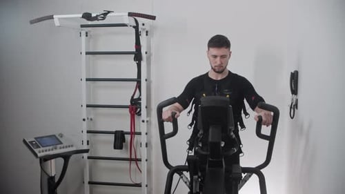 Ein Mann im Ems-Anzug trainiert im örtlichen Fitnessstudio