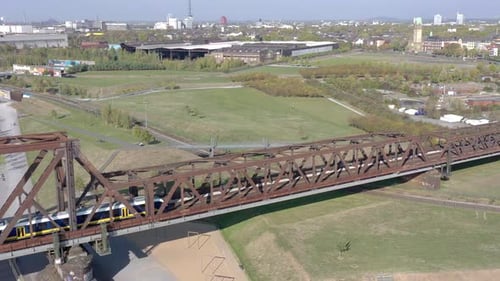 Commuter Train Passing Over an Old Iron Bridge
