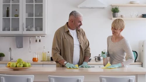 Couple Cleaning Kitchen Counter Together with Spray