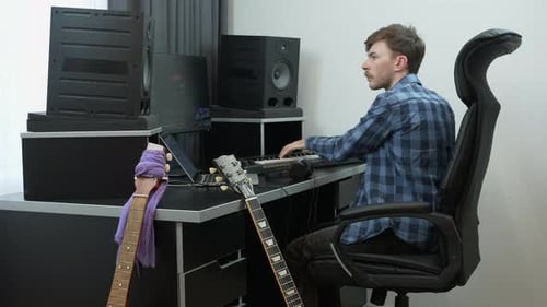 Professional musician and sound engineer composer recording and playing on midi piano keyboard