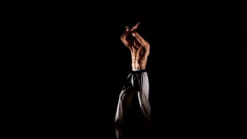 Man trainiert Karate oder Taekwondo isoliert auf schwarzem Hintergrund