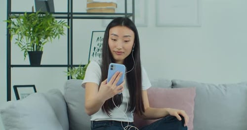 Woman Video Chatting on Phone, Sitting on Couch