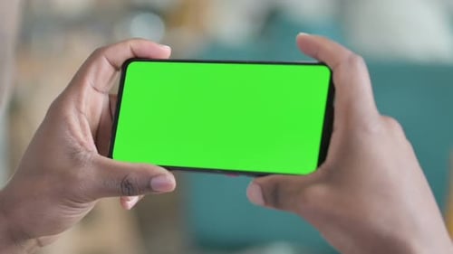 Close Up of African Man Holding Smartphone with Green Chroma Screen