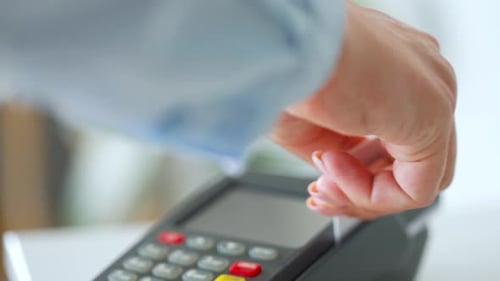 Hand Swiping Card on Payment Terminal Machine