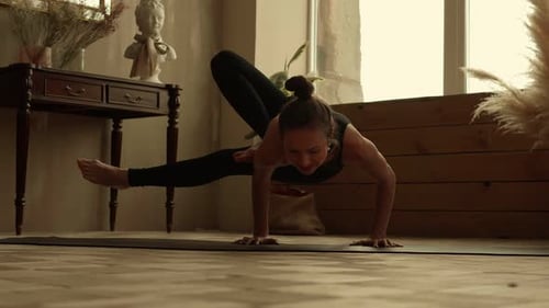 Sportlerin führt zu Hause ein komplexes Element des Yoga durch