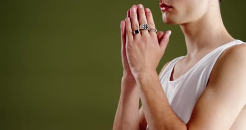 Androgynous man posing against green background